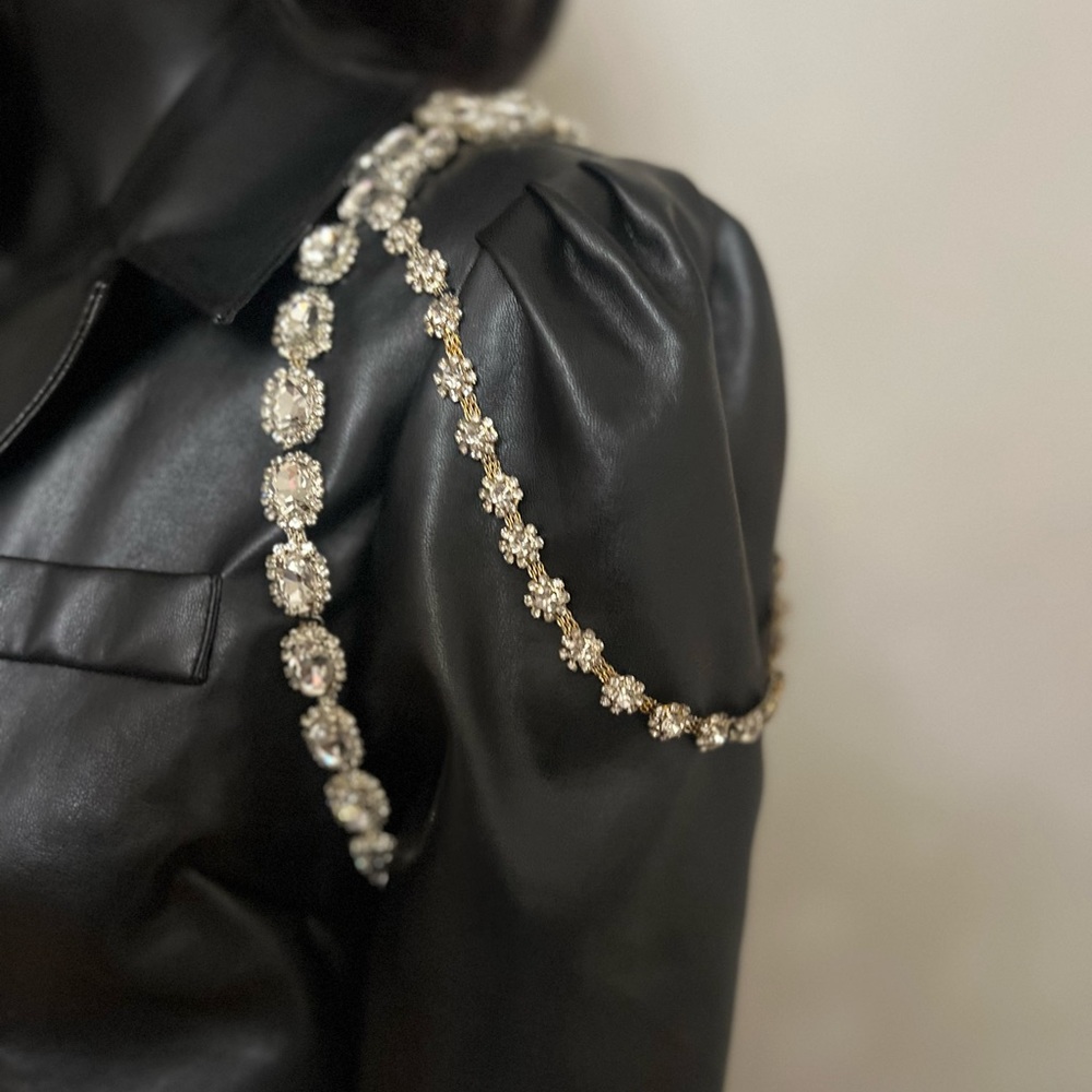 Black leather cropped jacket with jeweled shoulders.